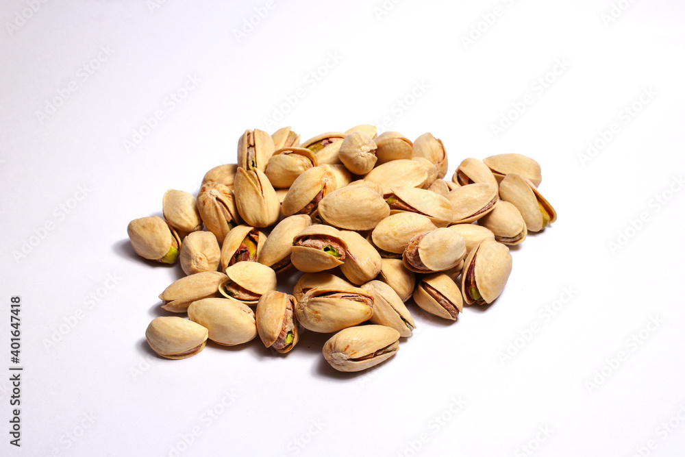 Gruppo di pistacchi tostati disposti su sfondo bianco. Gruppo di pistacchi tostati disposti su sfondo bianco.