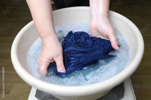 woman washes blue men's underpants, knitted underwear, clean clothes concept, scandal in the Russian Federal Security Service with her hands in a basin