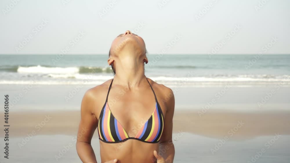 An adult slender woman practices yoga outdoors in nature