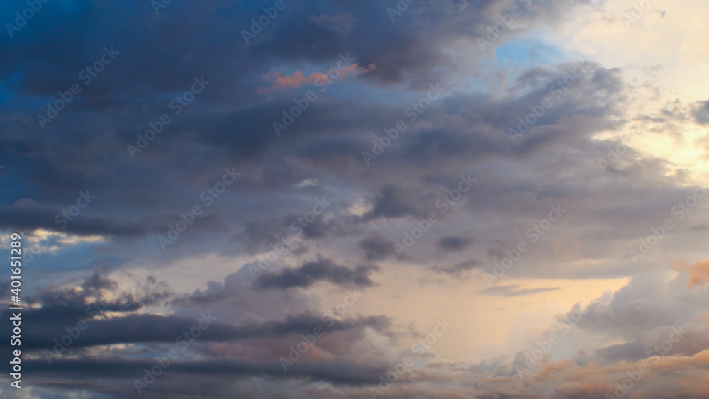 Magnifiques teintes orangées sous des nuages de moyenne altitude, pendant le coucher du soleil.  Le temps est instable