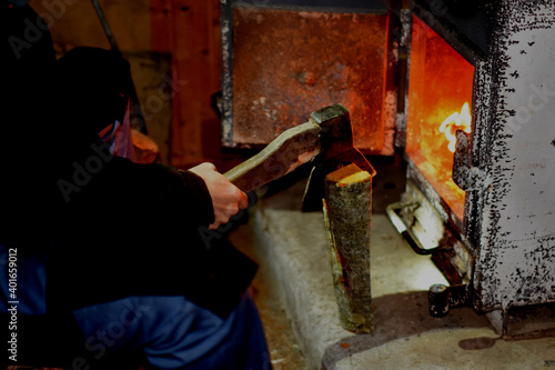 Fototapeta Naklejka Na Ścianę i Meble -  a man makes a fire in the oven