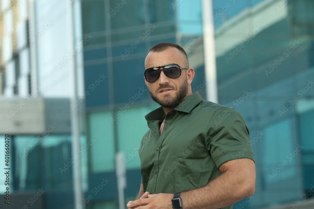 Sexy stylish man in sunglasses. City style. A beautiful and charming man with sunglasses outdoors. Sexy stylish man in sunglasses. City style. A beautiful and charming man with sunglasses outdoors.