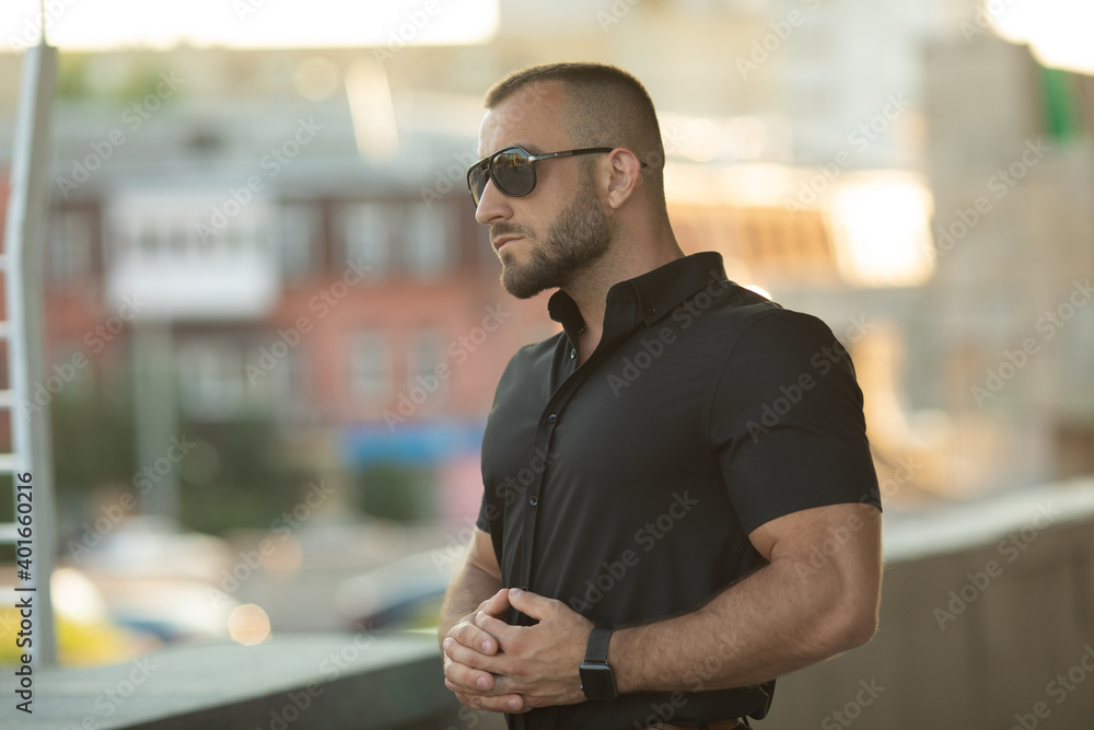 Sexy stylish man in sunglasses. City style. A beautiful and charming man with sunglasses outdoors. Sexy stylish man in sunglasses. City style. A beautiful and charming man with sunglasses outdoors.