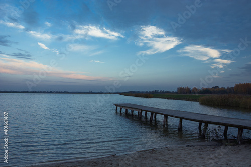 Lake shore with a wooden platform and evening sky