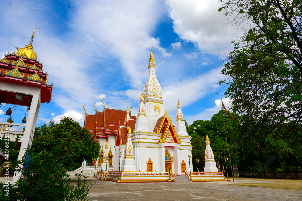 Naklejka premium Beautiful White buddhist pagoda on blue sky with white clouds,Wat Nong Khrok,Sisaket province,Thailand.