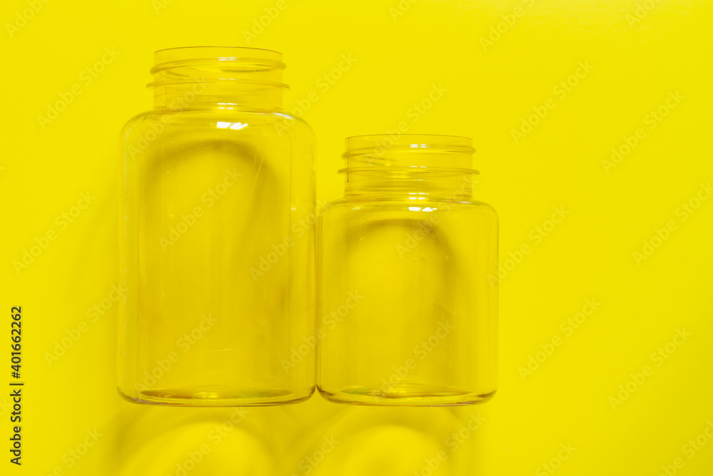Two transparent plastic empty cans on a yellow background. Copy space. Two transparent plastic empty cans on a yellow background. Copy space.