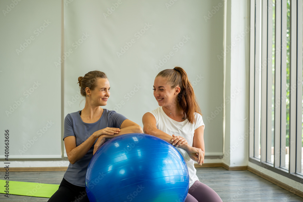 Caucasian woman practicing yoga exercise on yoga mat with teacher Caucasian woman practicing yoga exercise on yoga mat with teacher