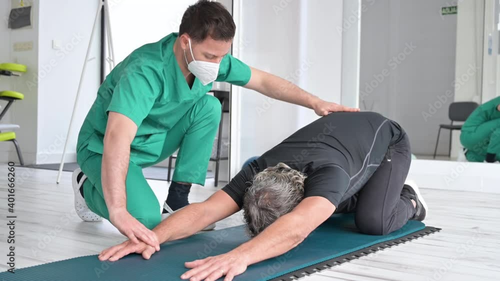 Therapist with protective face mask Assisting patient With Stretching Exercises. High quality 4k footage. Therapist with protective face mask Assisting patient With Stretching Exercises. High quality 4k footage.
