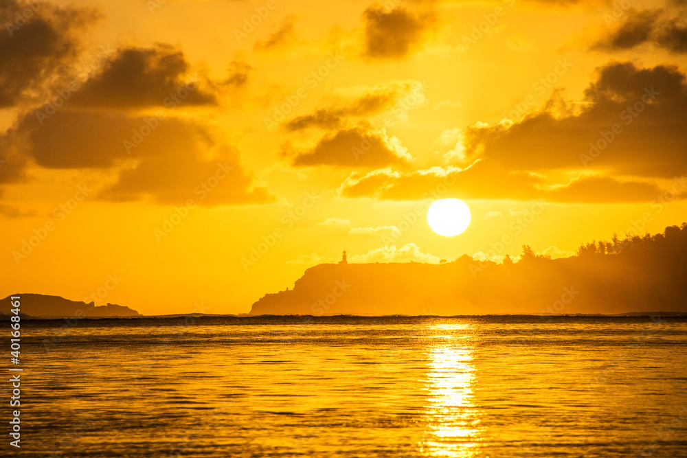 Naklejka premium Sunrise at Anini Beach in Kauai with silhouette of Kilauea Point and lighthouse
