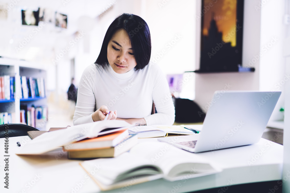 Thoughtful Asian student studying with books Thoughtful Asian student studying with books