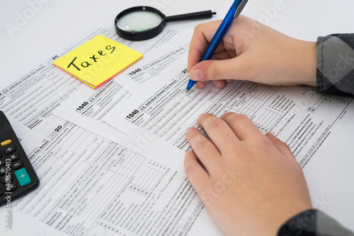 Close up hand filing US tax form. tax form us business income office hand fill concept