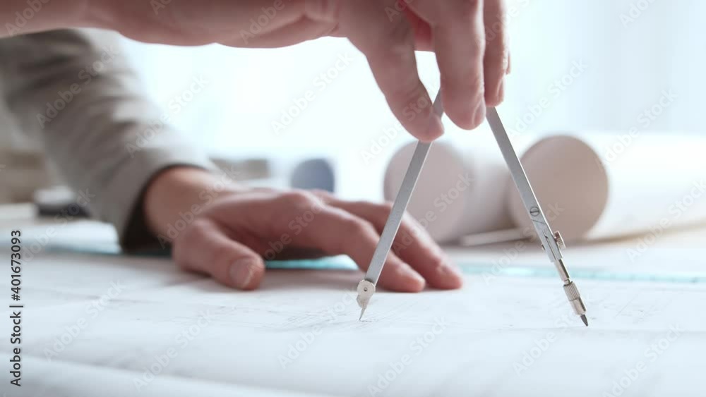 Close-up of an architect's hands. Professional real estate designer at the workplace in the office. Close-up of an architect's hands. Professional real estate designer at the workplace in the office.