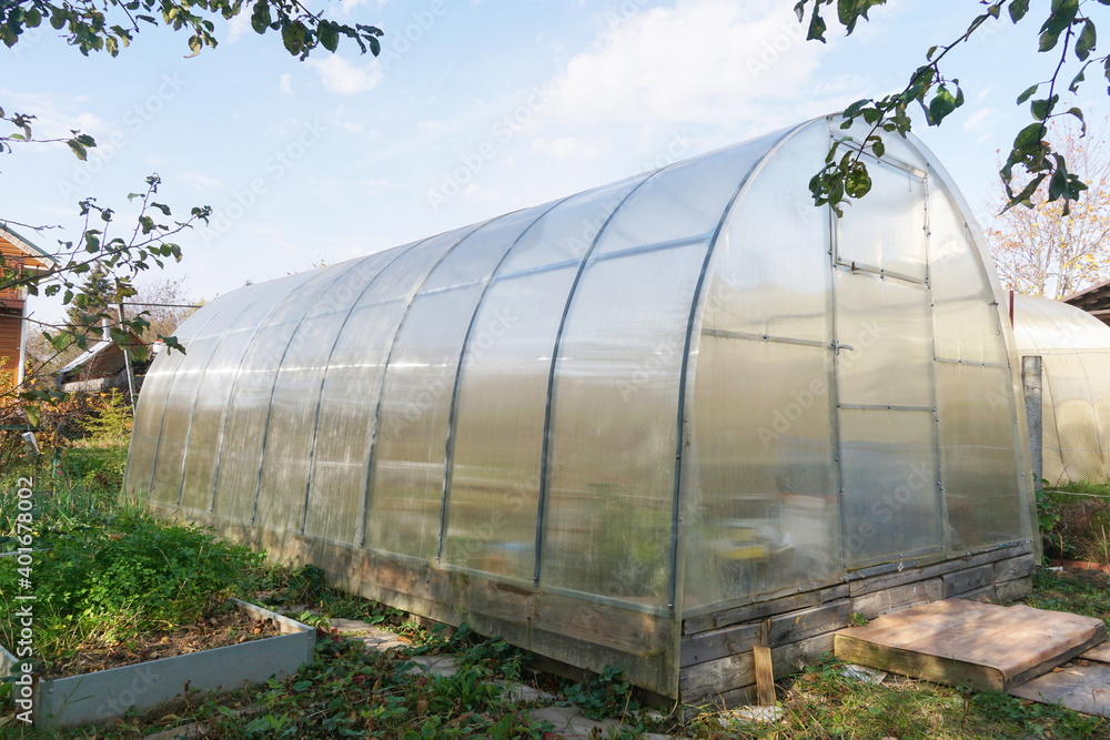 Frame polycarbonate greenhouse in the garden for many varieties of vegetables: tomatoes, cucumbers, paprika, etc.