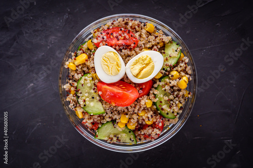 bowl of healthy quinoa with vegetables on a dark rustic background