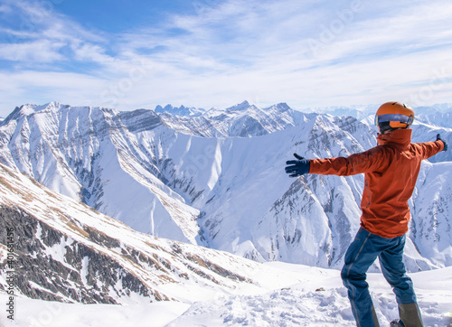 Male person stands on Gudauri top viewpoint and hugs snowy mountains concept.