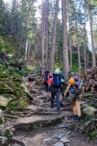 Young friends boys and girls walk in the mountains, along paths trought rocks and nature. 