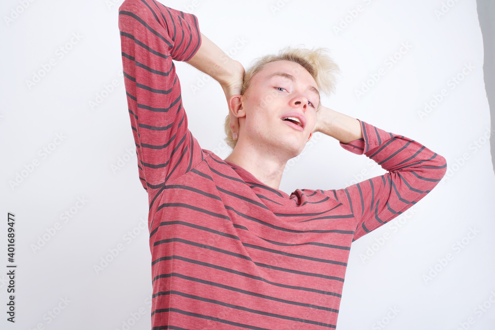Young handsome Caucasian blond man standing against white background Trying to hear both hands on ear gesture, curious for gossip. Hearing problem, deaf Young handsome Caucasian blond man standing against white background Trying to hear both hands on ear gesture, curious for gossip. Hearing problem, deaf