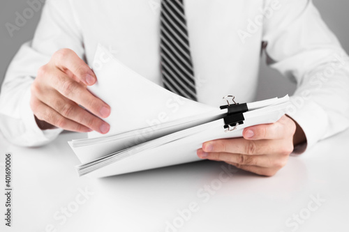 Businessman working in stacks of paper files for searching information on work desk home office, business concept.