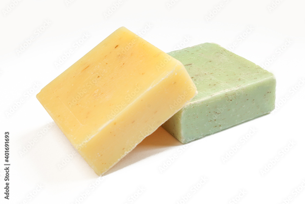 Two natural herbal soaps isolated on white background. Green and yellow square shaped products