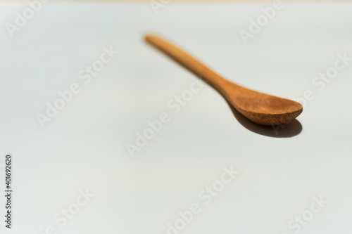 Cucharita de madera sobre fondo blanco con efecto  bokeh photo