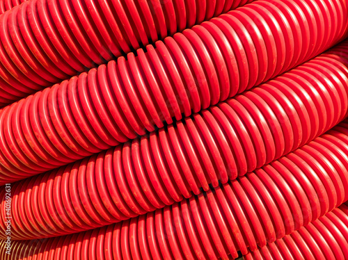 Reel of red flexible corrugated pipe, used for protecting cables in electrical installation.