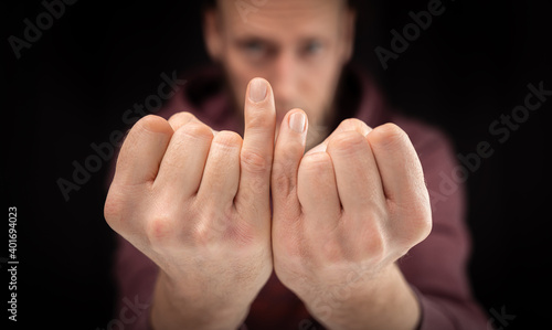 Hands of disabled man with different long pinkie finger shown into the camera