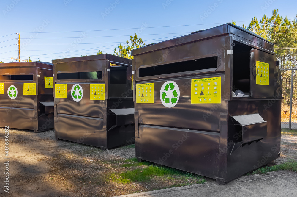 Single stream recycle center collection bins at local trash dump. Mixed recycling containers for household garbage at outdoor junkyard. Single stream recycle center collection bins at local trash dump. Mixed recycling containers for household garbage at outdoor junkyard.