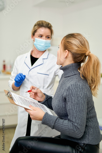 Patient in aesthetics clinic signs document
