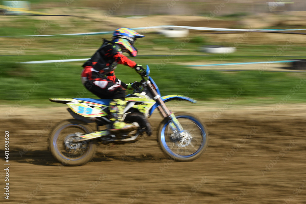 Unrecognized athlete riding a sports motorbike on a motocross racing