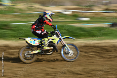Unrecognized athlete riding a sports motorbike on a motocross racing
