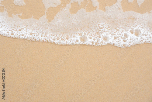 Soft ocean wave on tropical sandy beach for background with copy space.