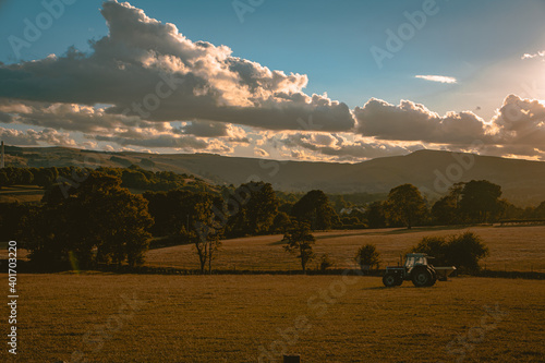 Tractor working in the sunset, landscape