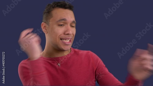 Attractive multiracial man dances happily after getting some good news