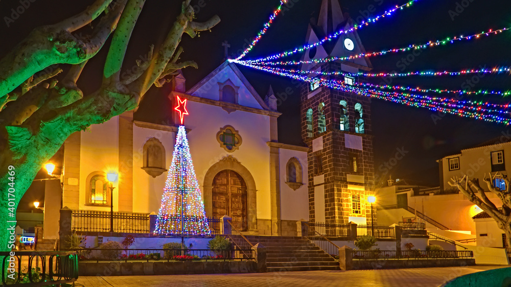Christmas lights in a small town on the Canary Island of Tenerife, colorful, bright and with illuminated palm trees.