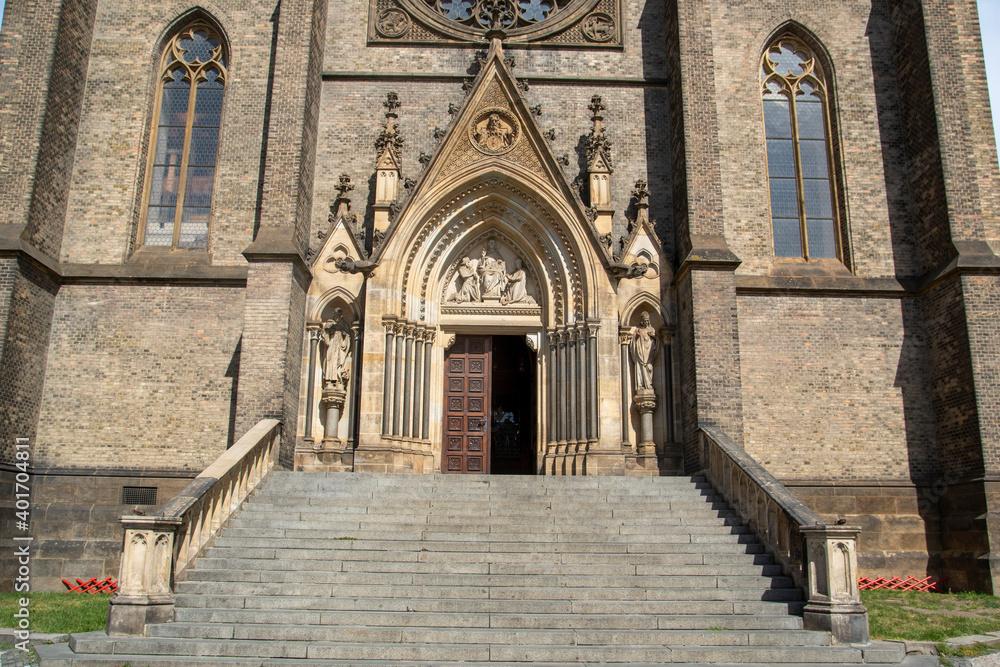 Entrance of a church in Prague with hard stone stairs and limestone ornaments.