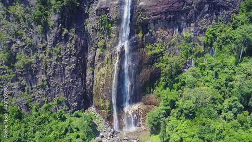 Wonderful Diyaluma falls with white jets on steep cliff in lush wild rainforest on sunny day bird eye view. Tropical vacation concept photo