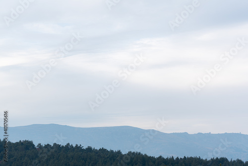 Mountains landscape minimalistic style scenic with pine tree forest blue cloudy sky