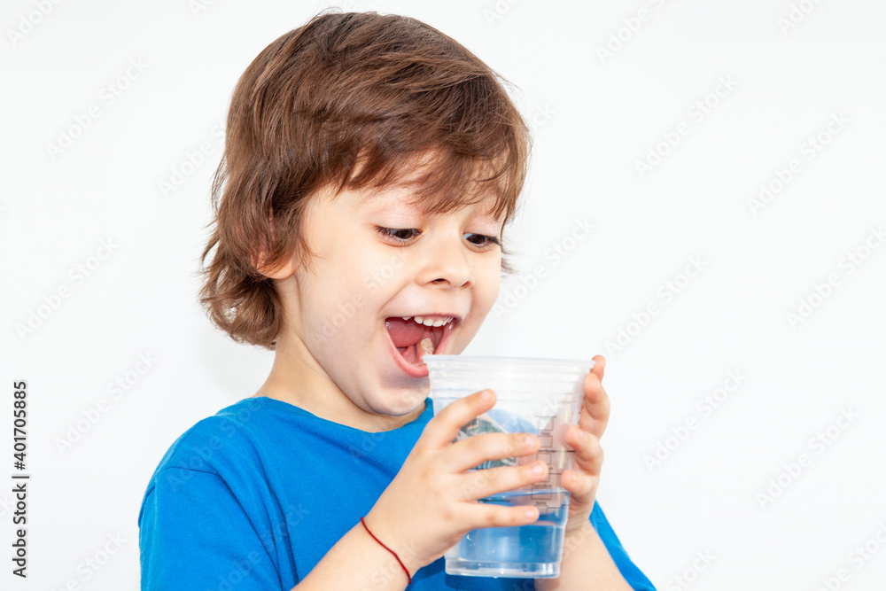 portrait of a boy with a glass of water on a light background portrait of a boy with a glass of water on a light background