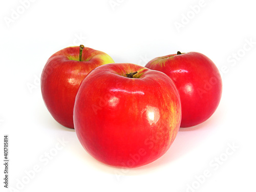 Three red delicious apples on a white background. 