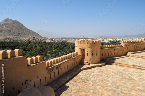 Beautiful view of Nakhal Fort's walls and mountains and a huge orchard of date palms outside it. Nakhal, Oman. photo