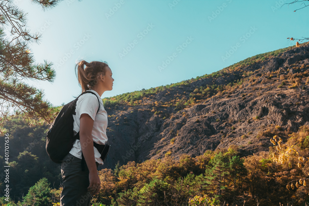 Traveler teen girl with backpack in mountains landscape. Hipster lifestyle. Happy travel concept and summer vacations outdoor
