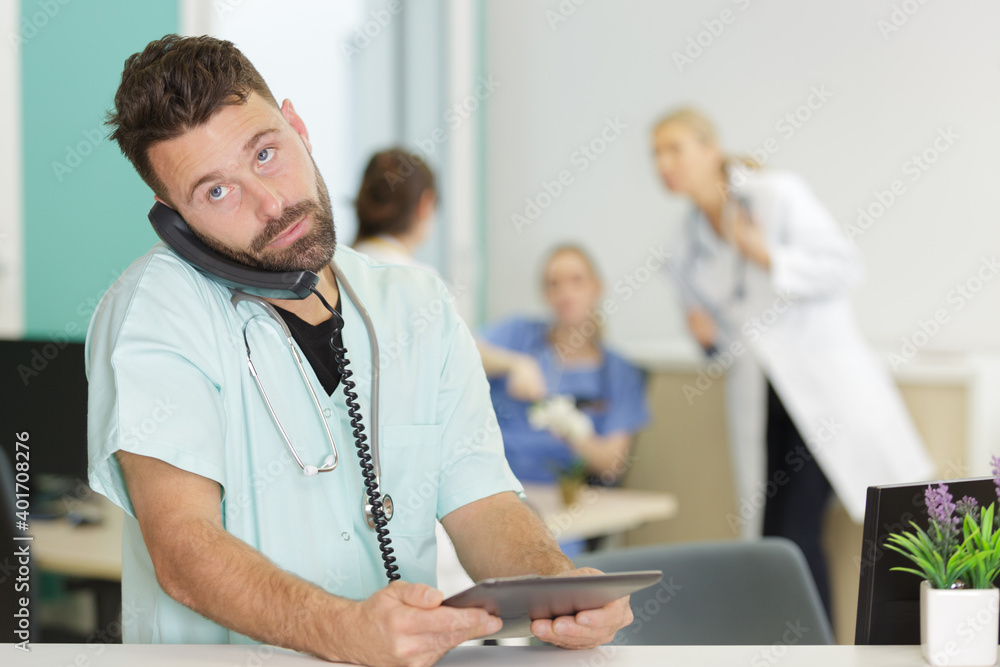 doctor on the phone holding the tablet - obrazy, fototapety, plakaty 