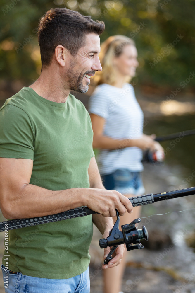 beautiful couple fishing in the pond using a fishing rod beautiful couple fishing in the pond using a fishing rod