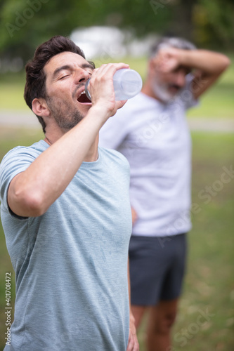 men drinking water after running