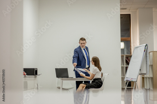 Angry boss yelling at his young employee, she is stressed and feeling frustrated: hostile boss and mobbing concept