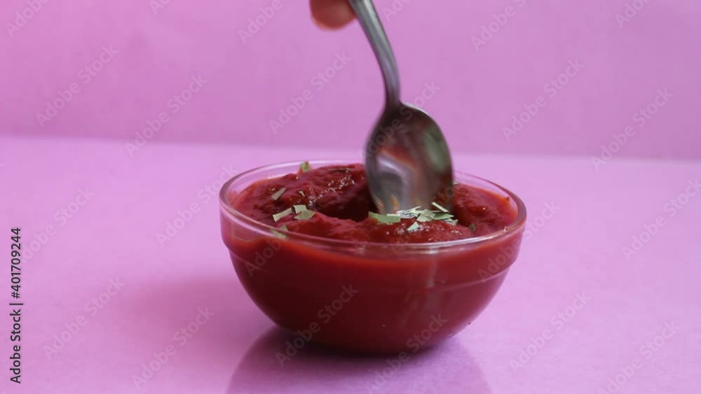 takes or puts a spoonful of red tomato sauce from a glass plate sauce takes or puts a spoonful of red tomato sauce from a glass plate sauce