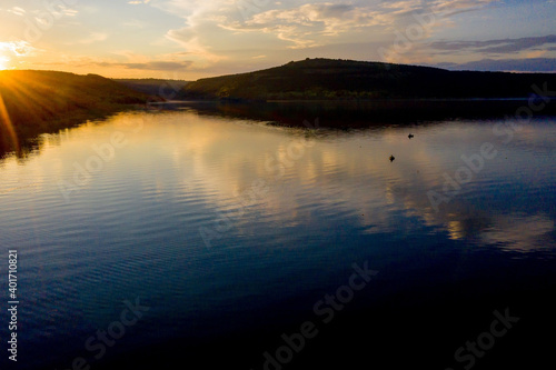 aerial view of fisherman at the boat on golden sunset river. silhouette of fishermen with his boat, Fisherman life style