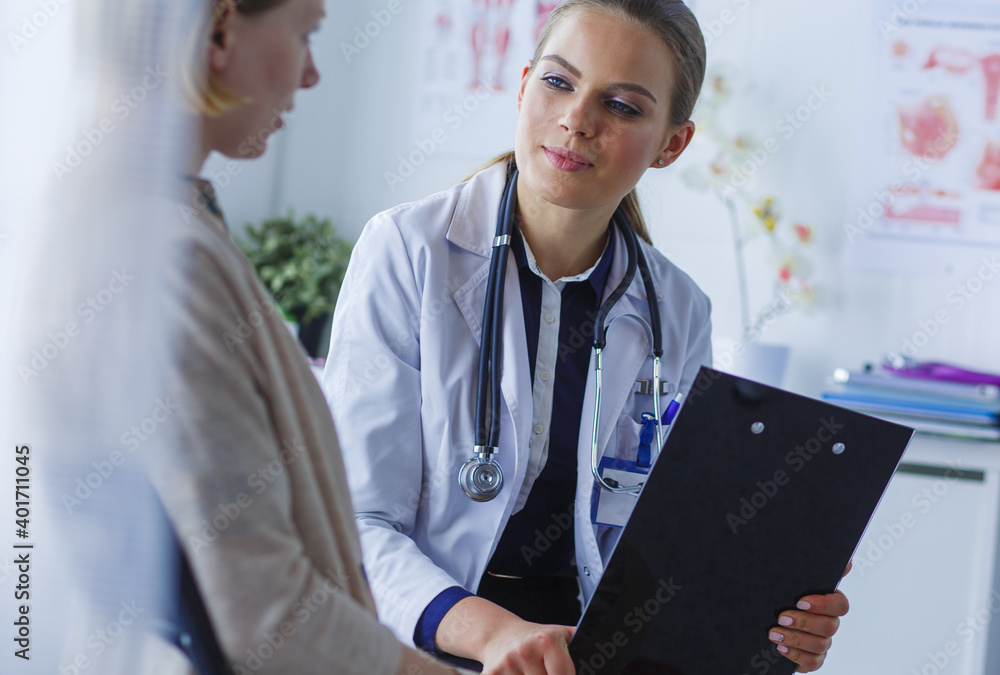 Doctor and patient discussing something while sitting at the table . Medicine and health care concept Doctor and patient discussing something while sitting at the table . Medicine and health care concept