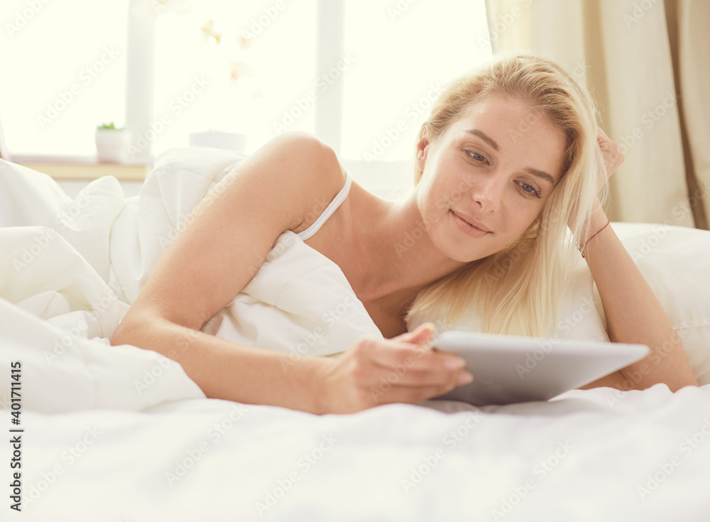 Girl holding digital tablet with blank screen and smiling at camera in bedroom Girl holding digital tablet with blank screen and smiling at camera in bedroom
