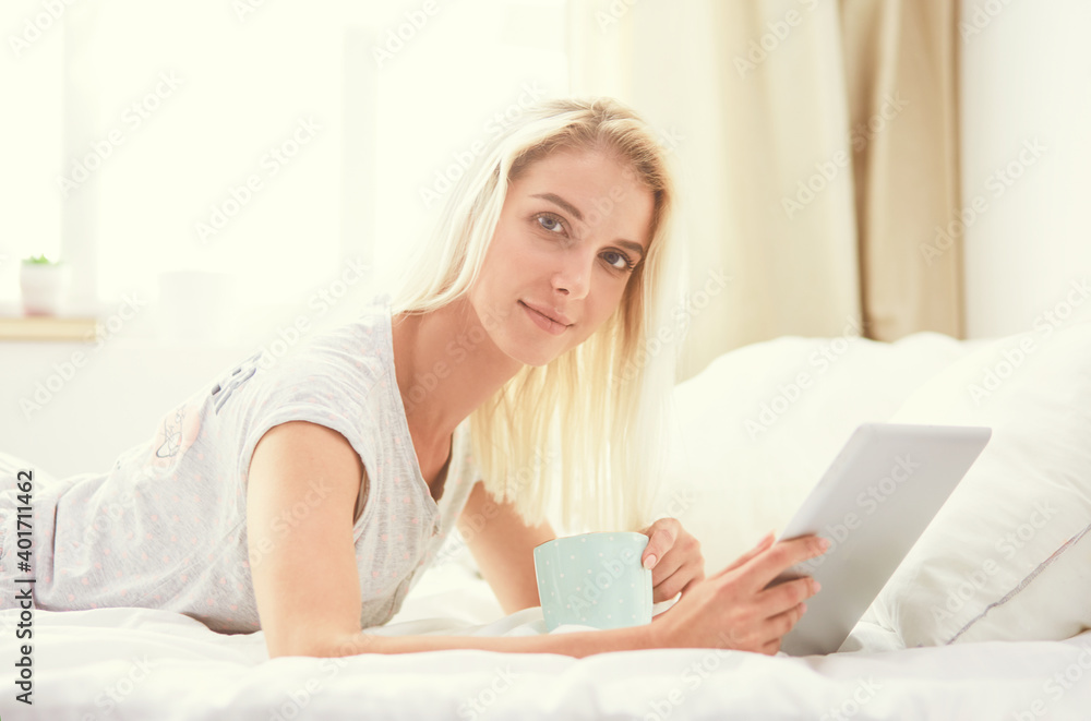 Girl holding digital tablet with blank screen and smiling at camera in bedroom Girl holding digital tablet with blank screen and smiling at camera in bedroom